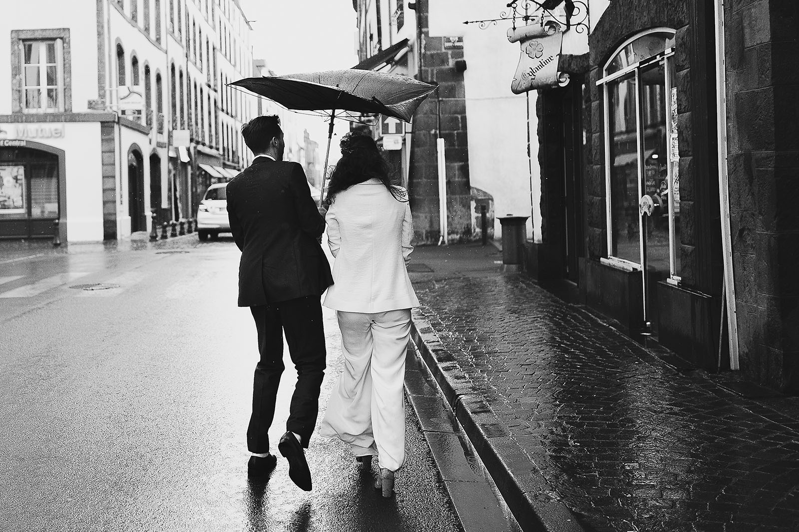 Photographe de mariage à Clermont Ferrand Les mariés sous la pluie avec le parapluie