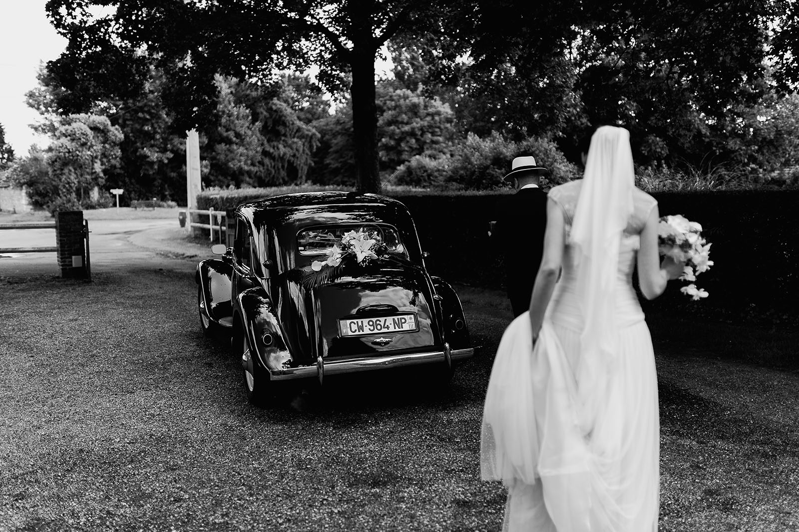 Mariage au Manoir de Corny en Normandie. La mariée rejoint sa voiture traction
