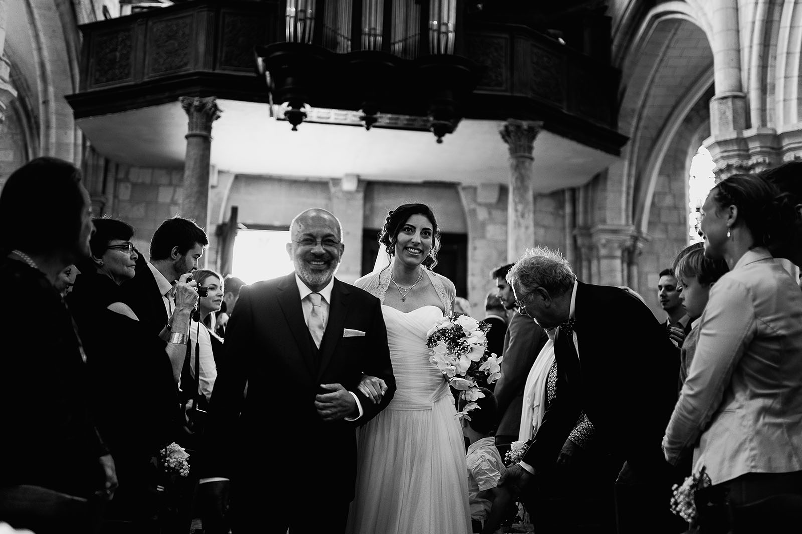 Mariage au Manoir de Corny en Normandie. Entrée de la mariée dans l'église au bras du papa