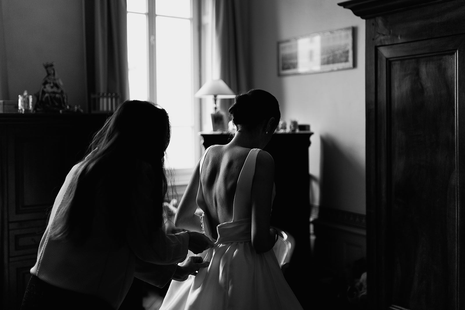Photographe de mariage à Lyon. Fermeture de la robe de la mariée