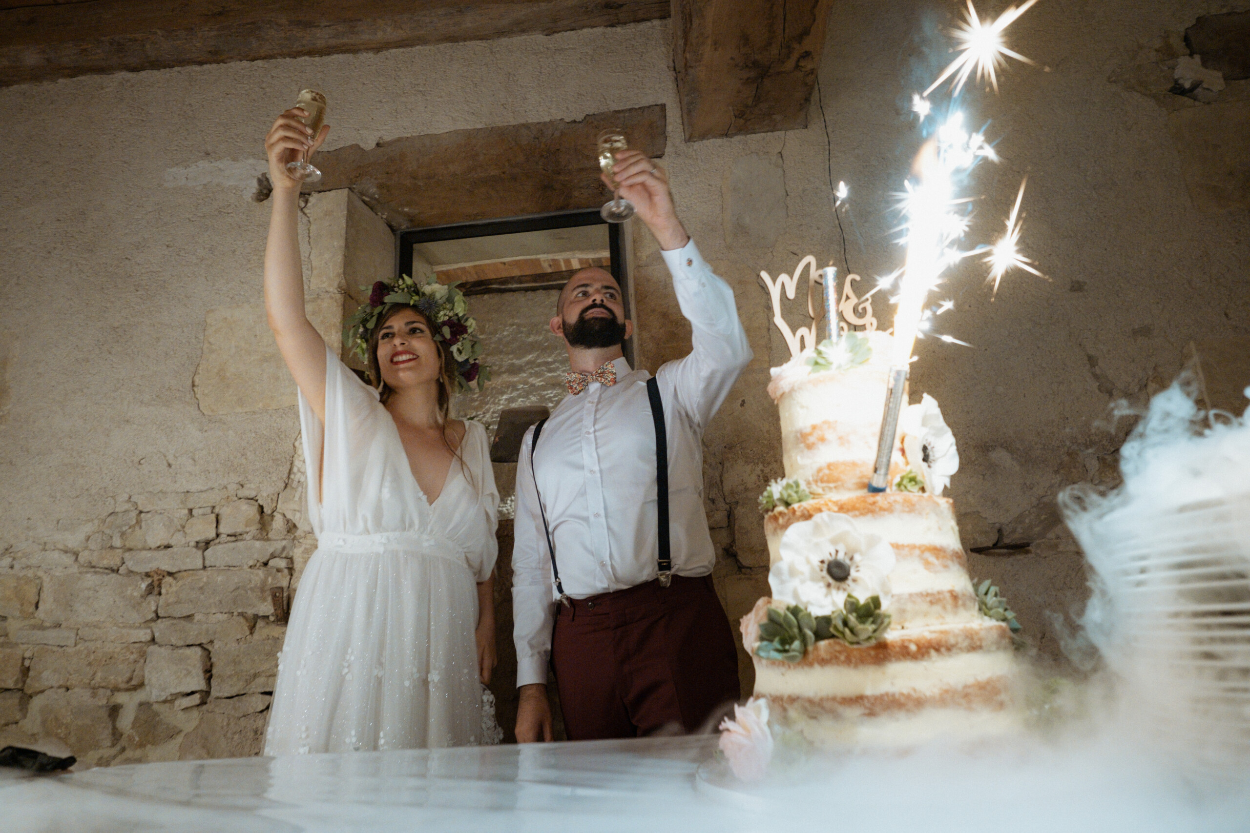 Les mariés trinquent au champagne durant la présentation du gâteau de mariage
